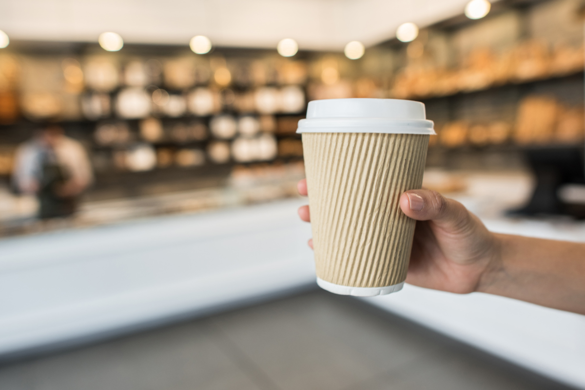 Hand holding a to-go coffee cup